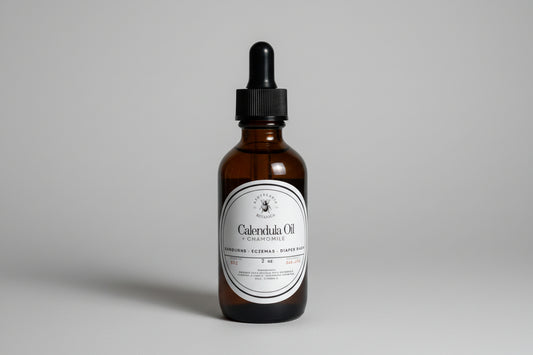 Brown glass bottle with dropper labeled 'Calendula Oil' on a gray background